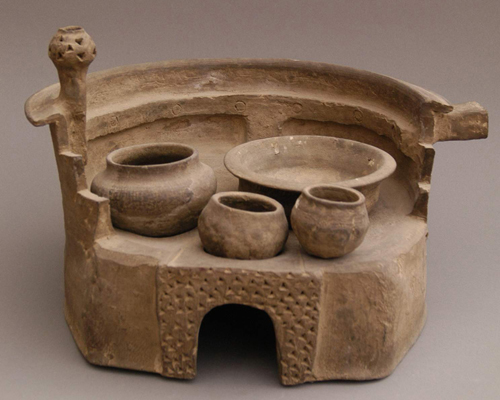 汉绳纹灰陶灶(国家二级文物) : 泥质红陶,体呈圆桶状,一套五件,灶面有三个火堂,带一罐两釜。拱形火门,火门周边有三角状戳纹饰。灶上部有半圆形档风墙,墙顶部为斜折沿,墙一侧饰壶形烟囱,上有三角状戳纹,一侧有方形空心短柄状烟道。灶壁饰细绳纹,整个灶造型奇特,具有较高的艺术性